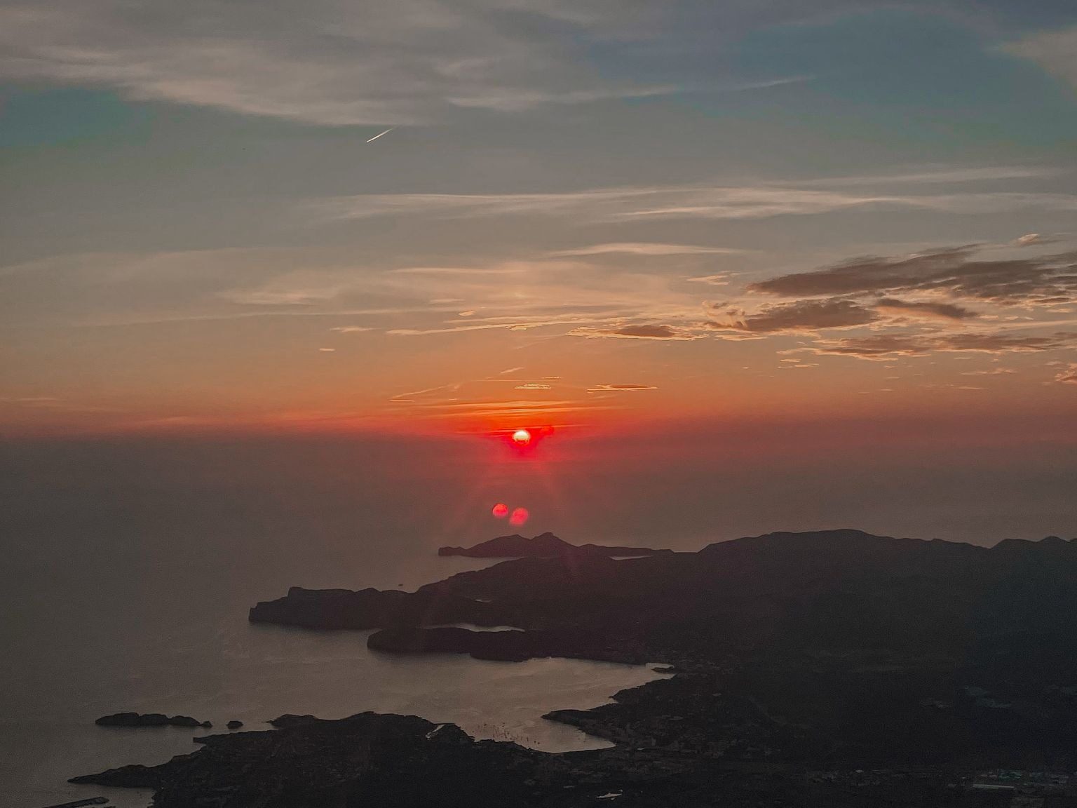 Atardecer sobre el mar y montañas